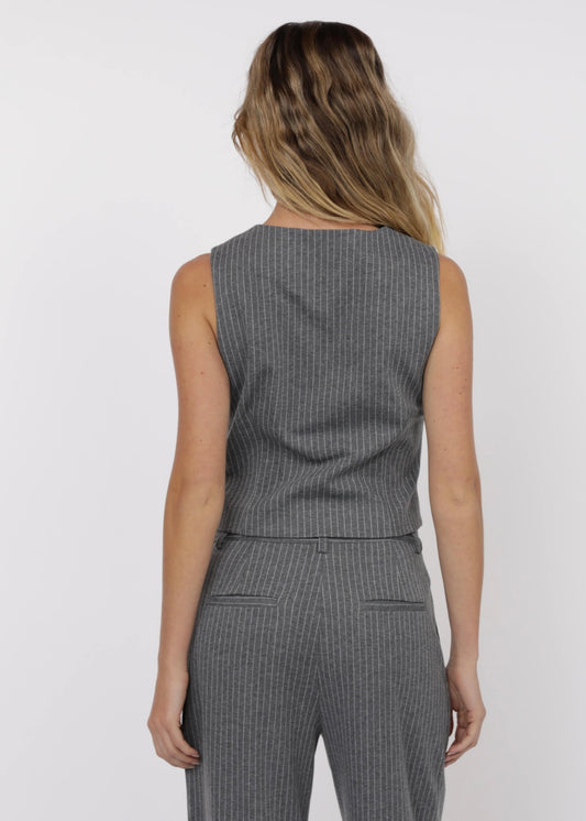 Woman wearing a gray pinstripe suit on a white background