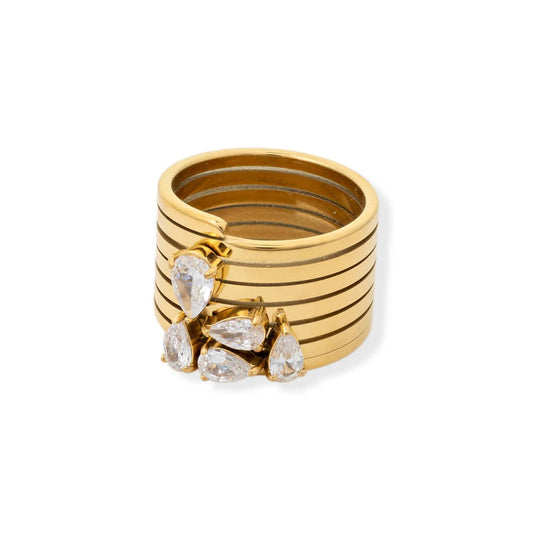 Stack of gold rings with pear-shaped gemstones on a white background