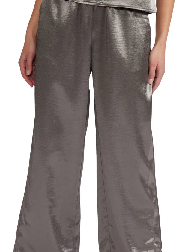 Silver metallic pants worn by a person on a white background