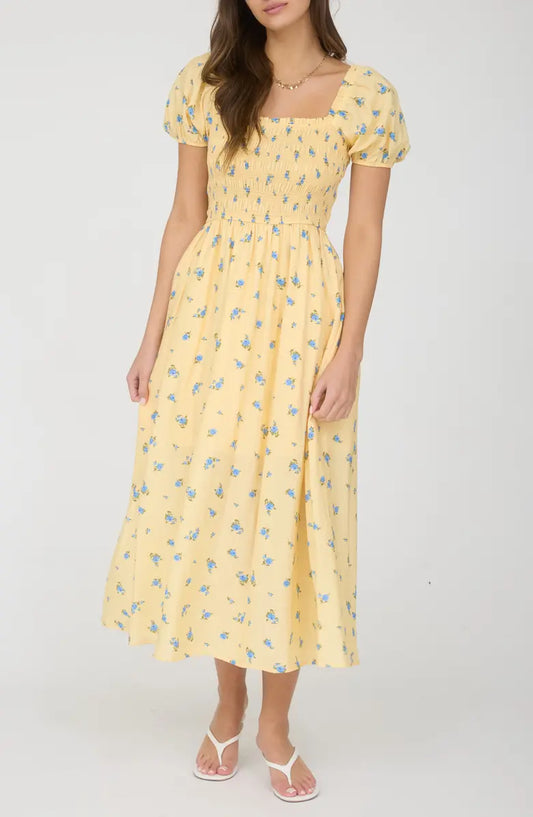 Woman wearing a yellow floral dress on a white background